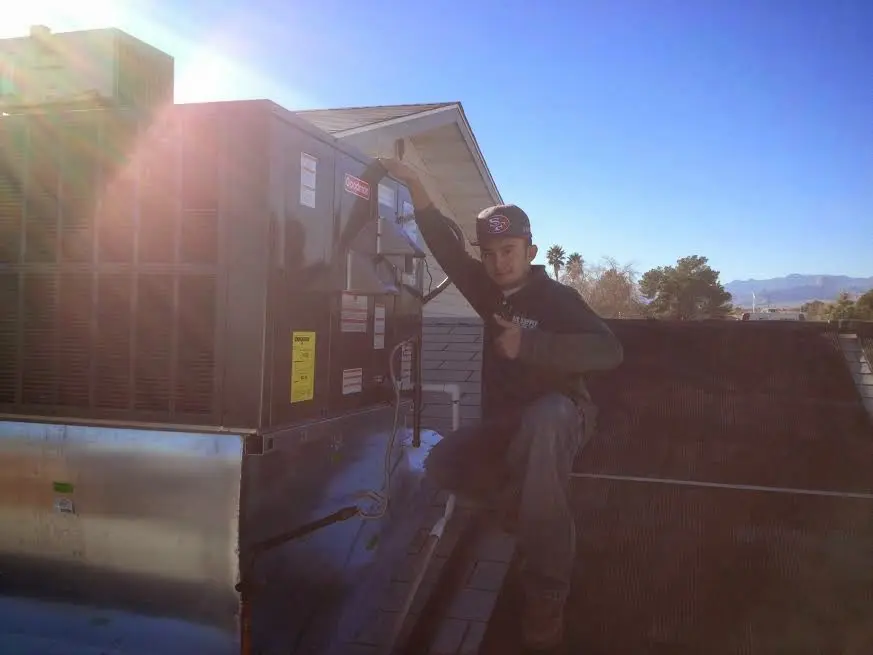 HVAC technician performing AC Tune-Up on a rooftop unit in Moraga